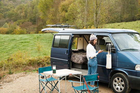 woman camping on van in the countryside