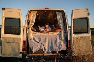 Man with phone using internet in camper
