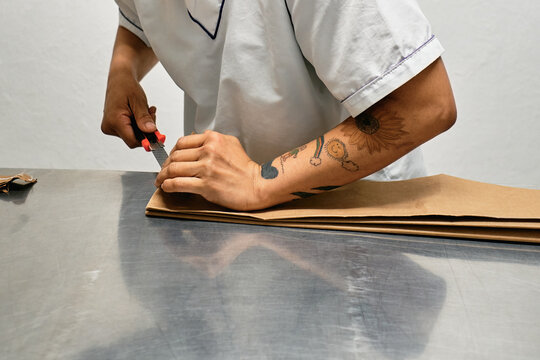 Employee cutting paper with a scalpel