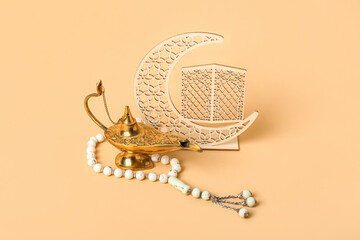 Aladdin lamp of wishes, prayer beads and decorative crescent for Ramadan on beige background