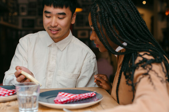 Couple looking at mobile sitting in restaurant table