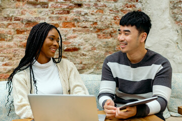 Two friends laughing while working together in modern work space