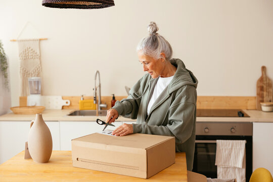 Mature woman unpacking order in kitchen
