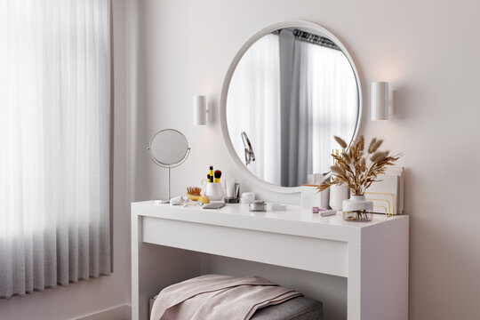 Cream, cosmetics, phone on dressing table. Interior shot.