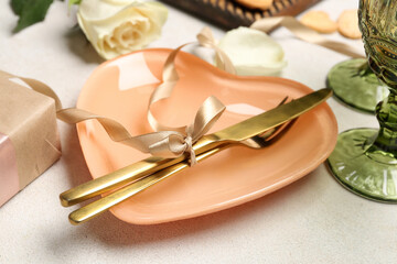 Fototapeta na wymiar Table setting with cutlery and beautiful bow on white background. Valentine's Day celebration