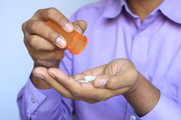 Fototapeta premium man's hand with medicine spilled out of the pill container 