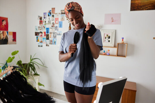 Optimist woman brushing fake hair