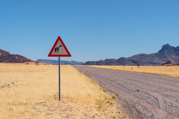 Giraffe crossing danger sign in a grassy plain in Namibia, Africa