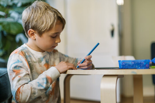 Boy sitting in his living room drawing pictures