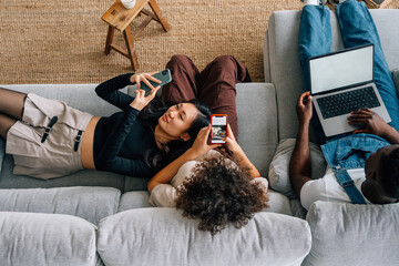 asian girl smiling while looking at the mobile with her friends 