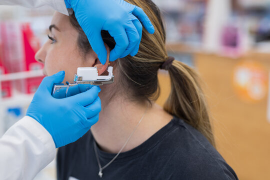 Woman having ear piercing process