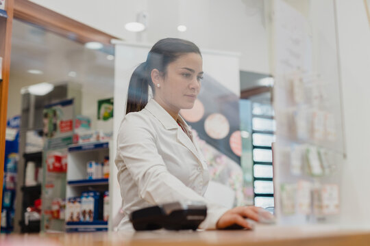 Female Pharmacist Standing at Checkout Counter 