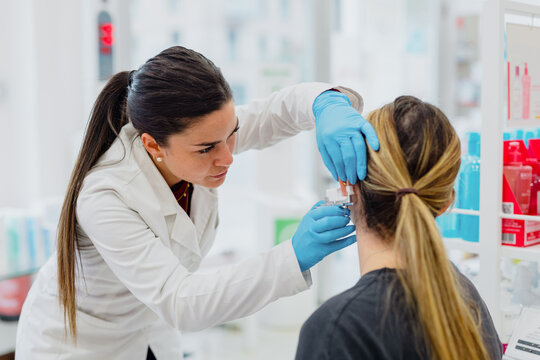 Woman having ear piercing process