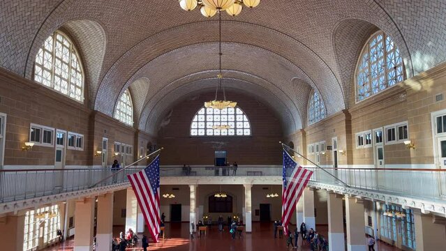 several tourists visit the hall of the former border post on Ellis Island. Indoor steady shot