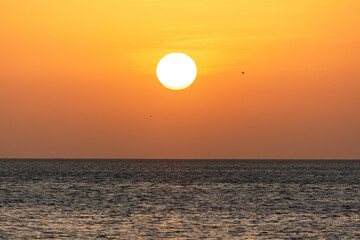 Sunrise with sun and orange sky, blue water of sea. Wallpaper