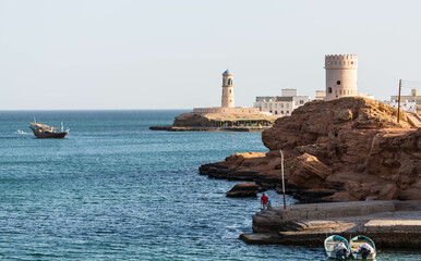 View of the Al Ayjah town, two watchtowers and a dhow under repair from the Khor Al Batah bridge in Sur, Oman