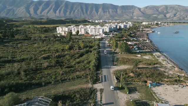 Aerial shot of cars driving through albanian city Orikum during sunrise
