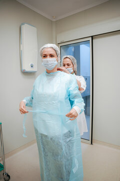 A female surgeon gets dressed before surgery