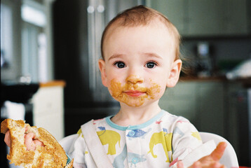 Messy Baby Eating Peanut Butter Toast for Breakfast