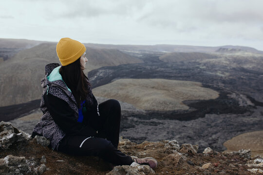 Scenery View Of young Women sitting on volcano in Iceland