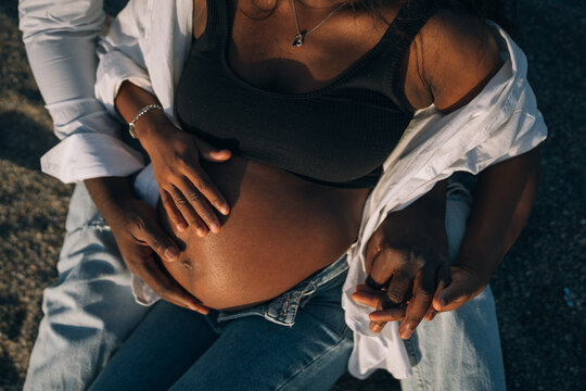 Crop black couple touching pregnant belly