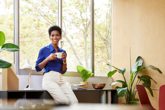 Successful pleasant black businesswoman having coffee break