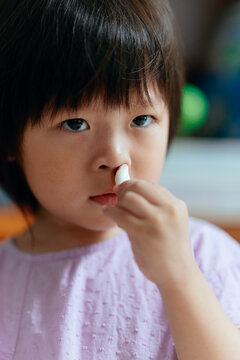 Child uses tissue to stop nosebleed