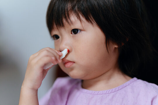 Child uses tissue to stop nosebleed