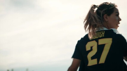 Medium close up shot of a female softball player throwing a caught ball with tremendous athleticism. After throwing she catches another ball.  Shot in glorious slow motion. - Powered by Adobe