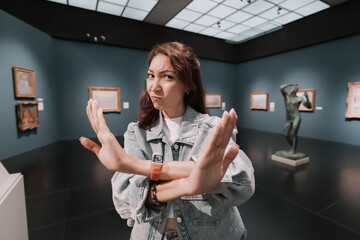 girl critic and expert visitor to a museum or art gallery showing no and stop sign