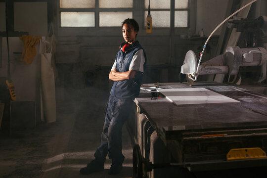 Focused craftswoman working with marble in workshop