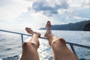 POV man feet towards ocean resting