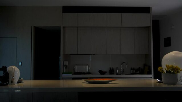 Shot of luxury kitchen with smart lighting, lights dim up (4K)