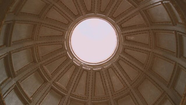 Dome of a church in Nazare seen from inside, intrados, circular base, with central hole and view of the sky, in Portugal, Extremadura
