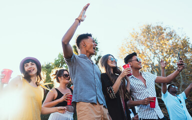 Drinks, party and a crowd of friends outdoor to celebrate at festival, concert or summer social event. Diversity young men and women people together while dancing, happy and excited with alcohol