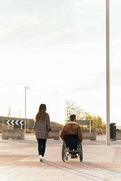 Man in Wheelchair with his Girlfriend in the Street