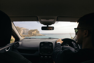 Man driving a car with the steering wheel on the right hand side