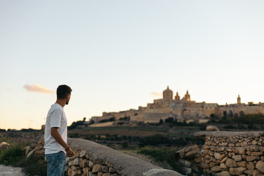 Young man looking at the views from outside the walls of Mdina