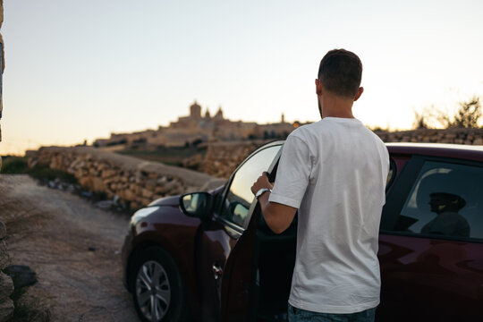 Young man getting into the car near Mdina, Malta.