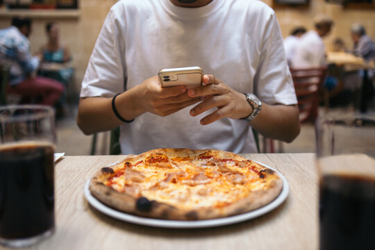 Young man taking a picture of his food before eating