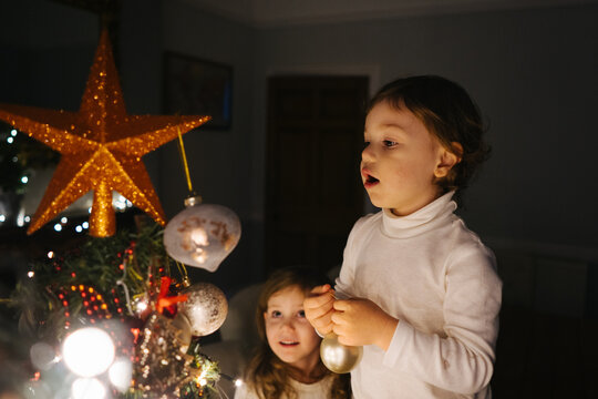 Two children decorates Christmas tree