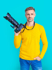 smiling man photographer with camera isolated on blue. man photographer with camera