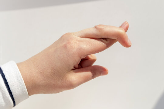 gesture and body parts concept - close up of hand showing two crossed fingers