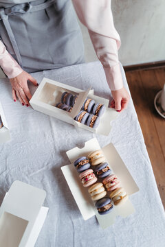 Packaging of macarons cakes in present boxes.