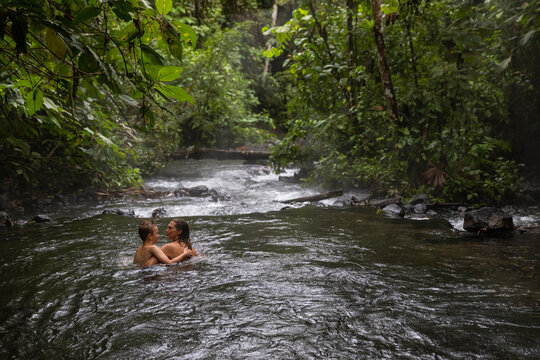 Mother and Son hug in river together in Costa Rica 