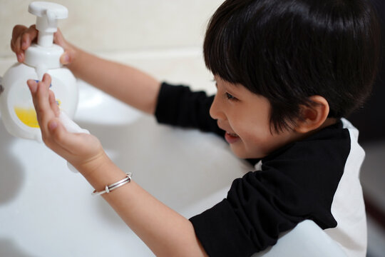 Asian little boy, washing hands in bathroom at home