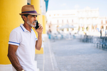 Serious aged man having phone conversation