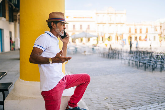 Cuban man talking on phone gesticulating