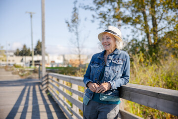 Senior woman outside in sun looking thoughtful.