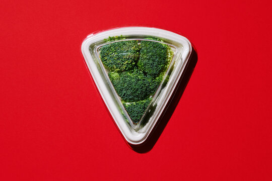raw broccoli in a triangular-shaped paper tray